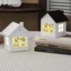 Đồng hồ báo thức hình ngôi nhà với màn hình LED hiển thị giờ, ngày tháng và nhiệt độ. Thiết kế nhỏ gọn, phong cách tối giản, phù hợp đặt trên bàn làm việc, tủ đầu giường hoặc trang trí phòng ngủ, phòng trẻ em.