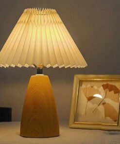 Đèn bàn gỗ sồi Bắc Âu chao vải xếp nếp màu kem, thân gỗ nâu đậm sang trọng. Thiết kế tối giản, ánh sáng ấm, tạo không gian thư giãn. Chất liệu gỗ tự nhiên cao cấp, phù hợp phòng ngủ, phòng khách, văn phòng.