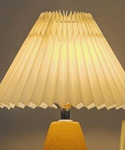 Đèn bàn gỗ sồi Bắc Âu chao vải xếp nếp màu kem, thân gỗ nâu đậm sang trọng. Thiết kế tối giản, ánh sáng ấm, tạo không gian thư giãn. Chất liệu gỗ tự nhiên cao cấp, phù hợp phòng ngủ, phòng khách, văn phòng.