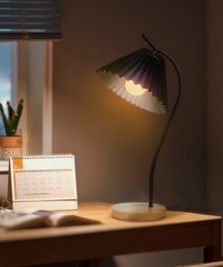 Đèn bàn decor thân uốn nghệ thuật kết hợp chao vải xếp nếp và đế gỗ tự nhiên. Ánh sáng vàng dịu nhẹ, phong cách Bắc Âu tối giản, tạo điểm nhấn hoàn hảo cho bàn làm việc và phòng ngủ. Mua ngay tại Co-Home Decor.
